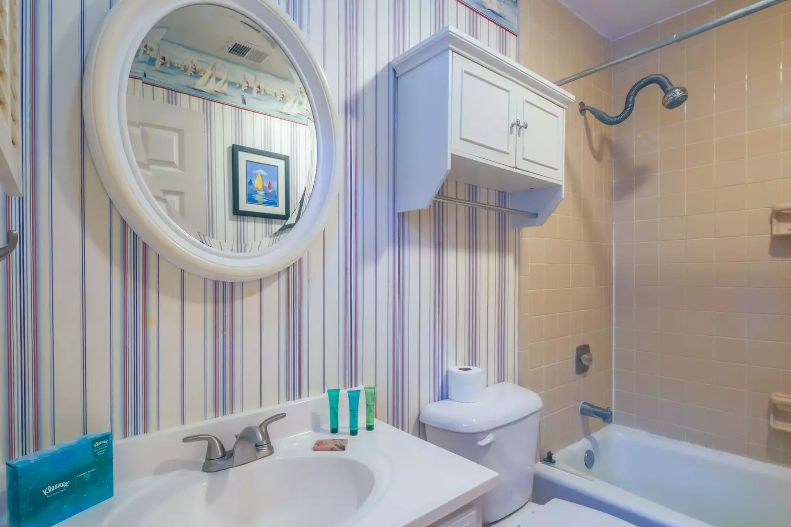 This hallway bathroom features a vanity and shower/tub combo.