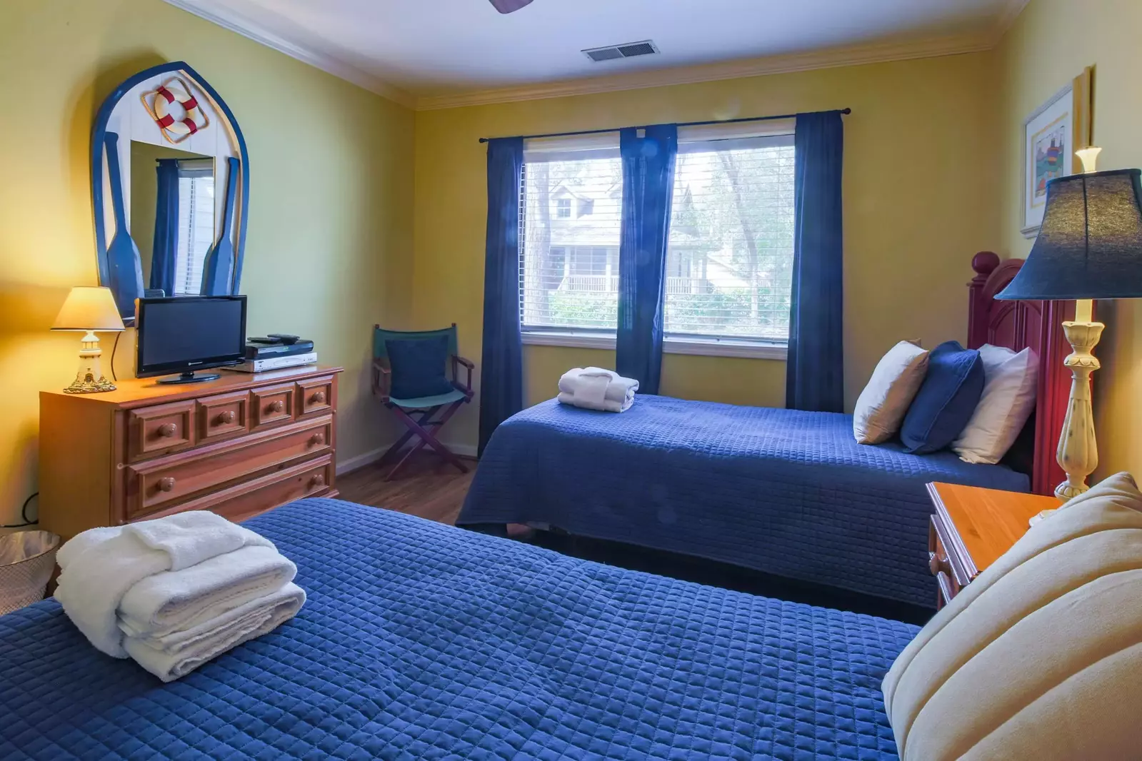 This guest bedroom also features a dresser and small TV.