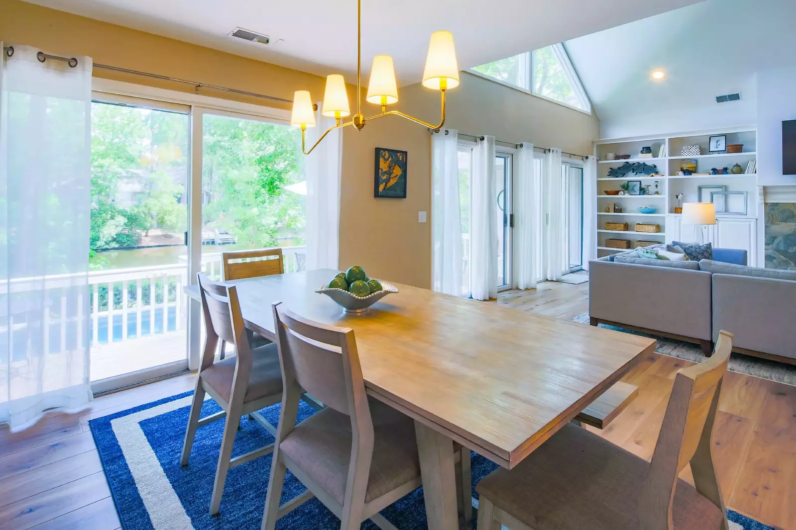 The living room flows into the dining area with a dining table that seats 6.