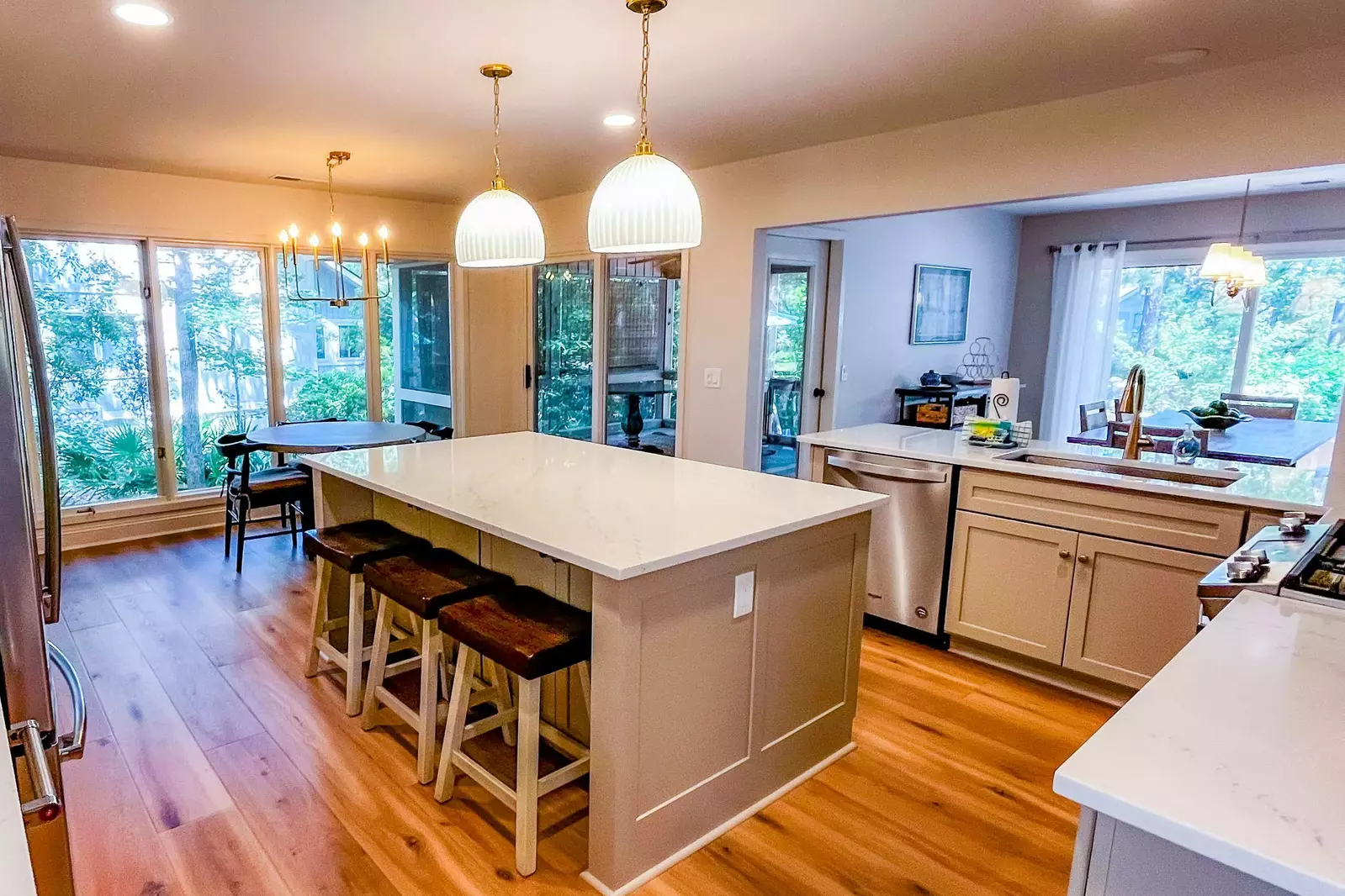 There are three stools at the central island as well as another dining table within the kitchen.