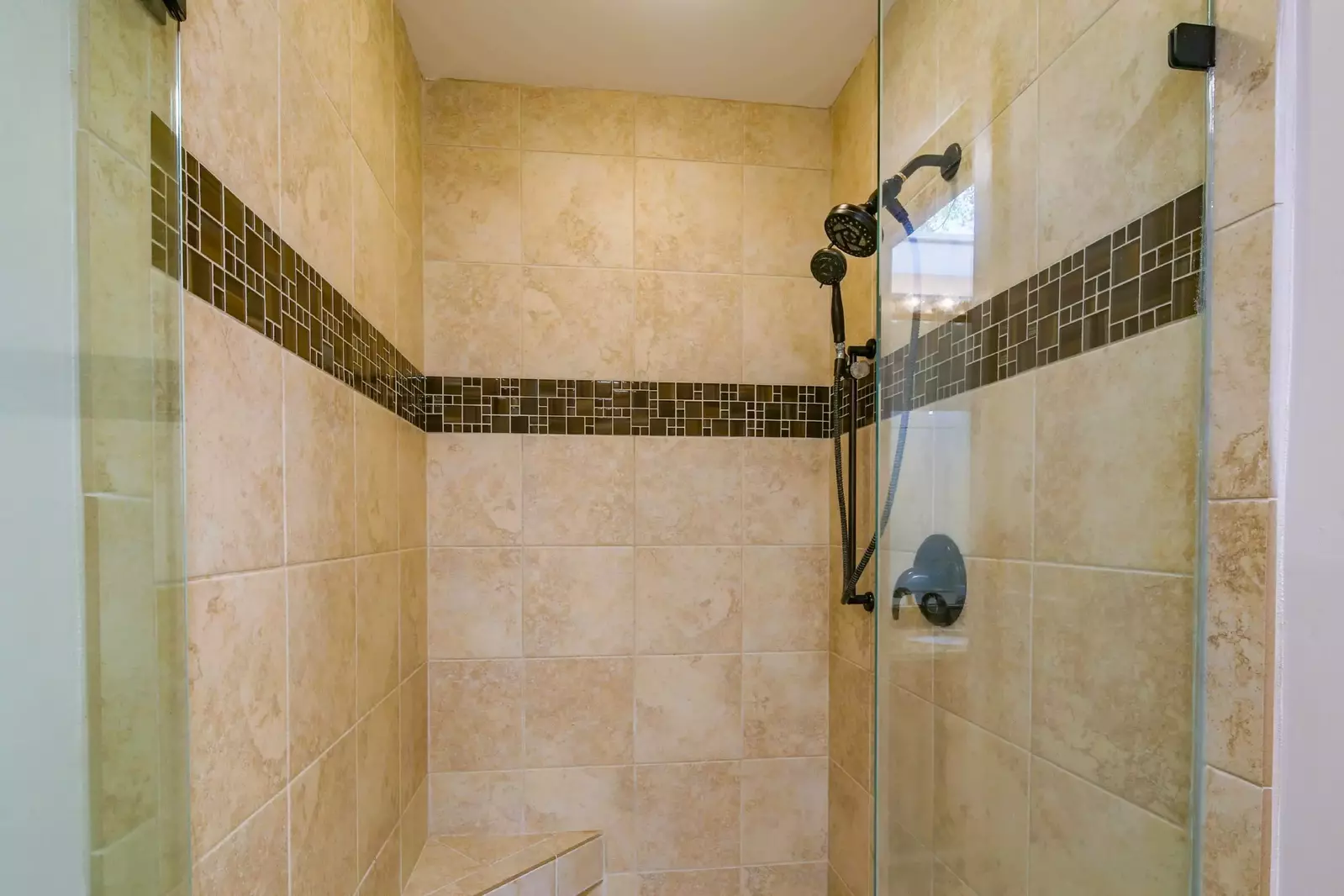 The en suite bathroom also has a tiled, walk-in shower with two shower heads.
