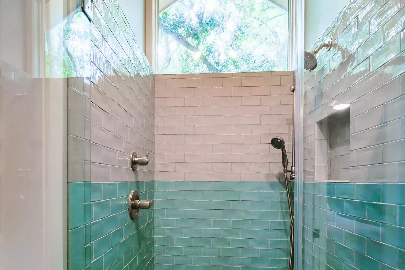 This beautifully tiled walk-in shower features two shower heads.