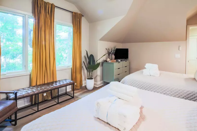 There is also an arm chair, bench, dresser and flat screen TV in this guest bedroom.