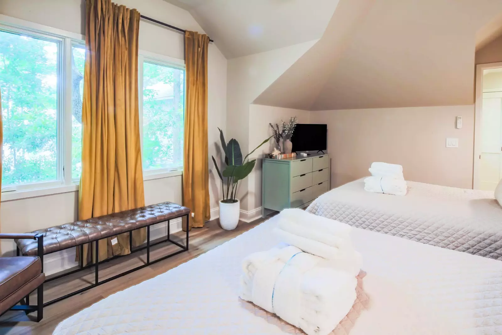 There is also an arm chair, bench, dresser and flat screen TV in this guest bedroom.