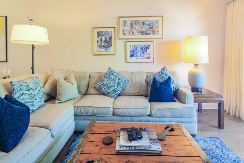 The living room features a large sectional sofa and lamps for soft lighting.