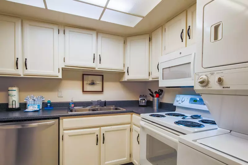 There is a stacked washing machine & dryer in the kitchen.