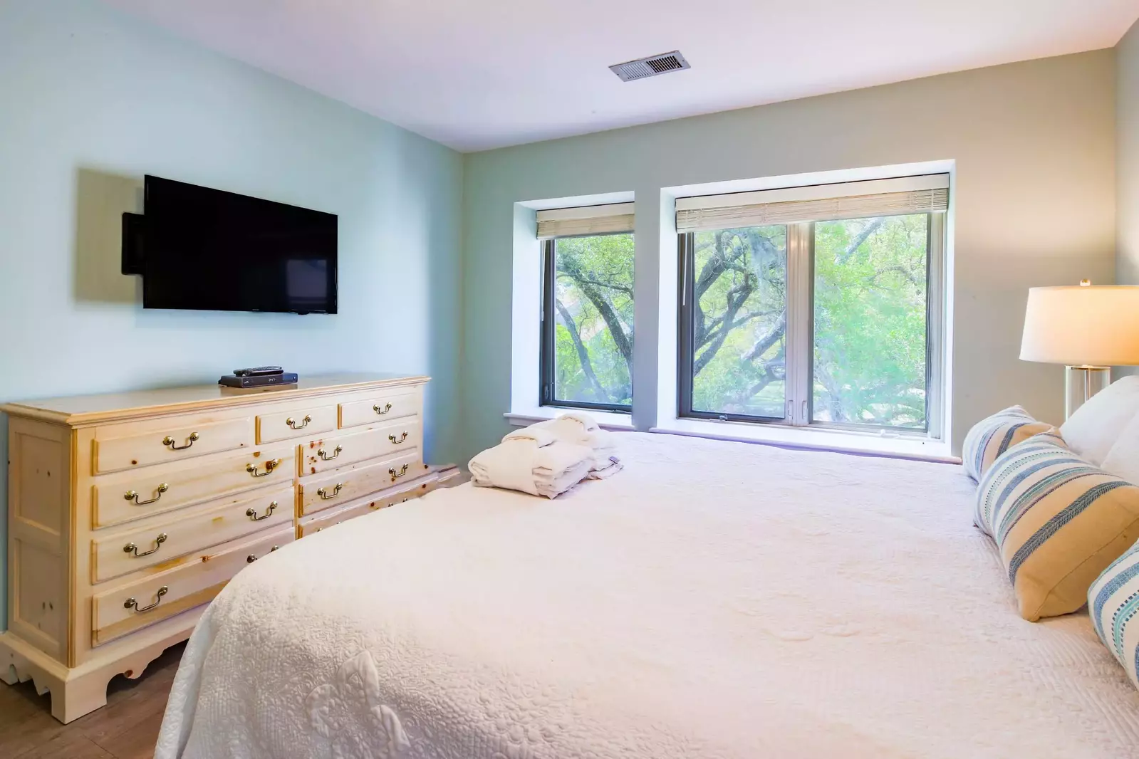 The master suite features a dresser and wall-mounted TV.
