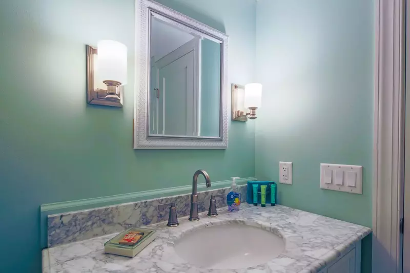 The master en suite has a spacious vanity and wall sconces.