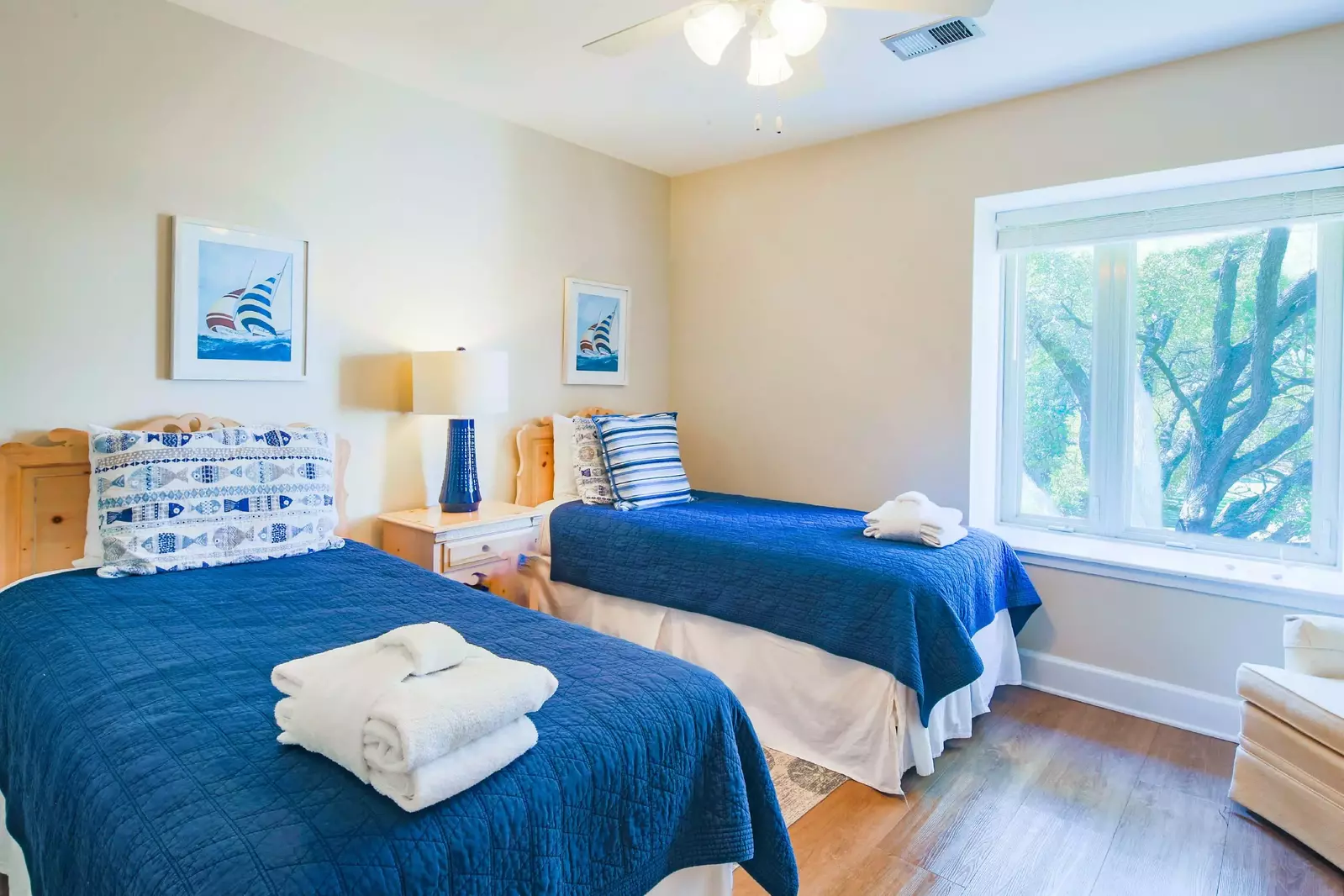 The guest bedroom features two twin beds and a night stand with reading lamp.