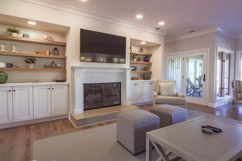 The living room features a wall-mounted TV, built-in bookcases and shiplap accent walls.
