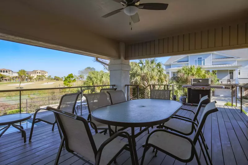 The spacious covered deck features an outdoor dining table, gas grill and steps down to the private pool.