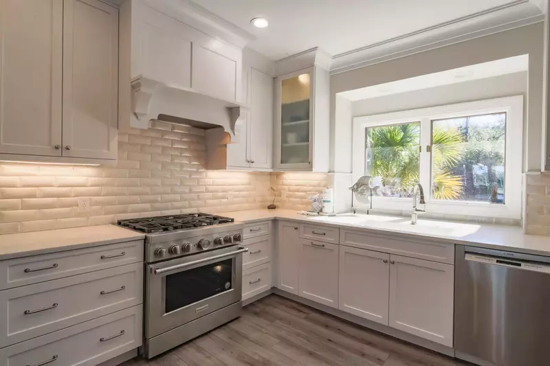 The kitchen boasts custom cabinetry, a tiled backsplash and a gas range.