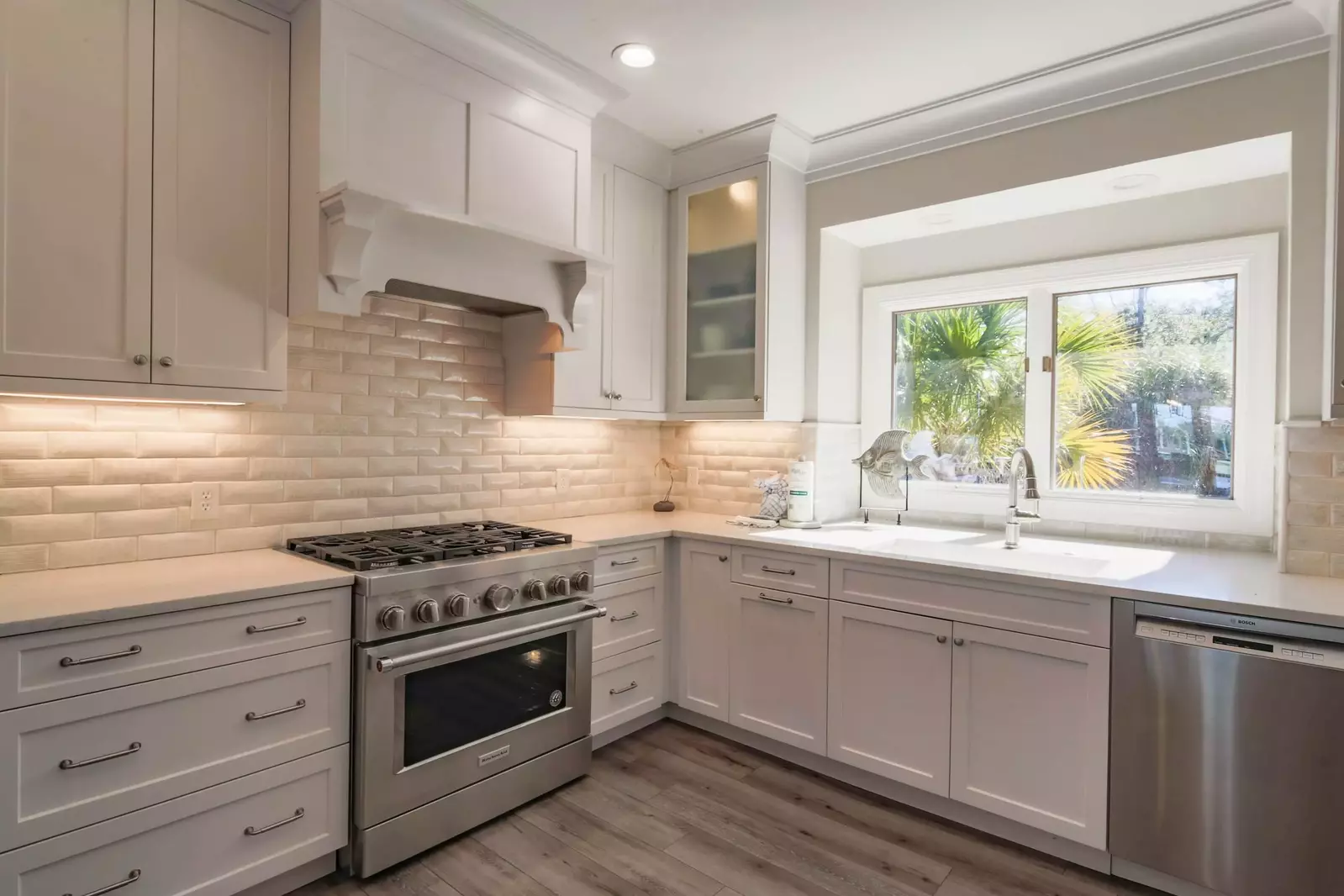 The kitchen boasts custom cabinetry, a tiled backsplash and a gas range.