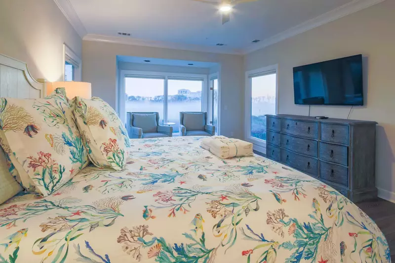 The master suite also has a dresser and wall-mounted TV.