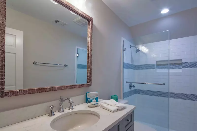This en suite bathroom for the Queen Suite features a spacious vanity and a tiled, walk-in shower.