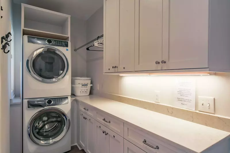 There is a stacked washing machine & dryer in the home.