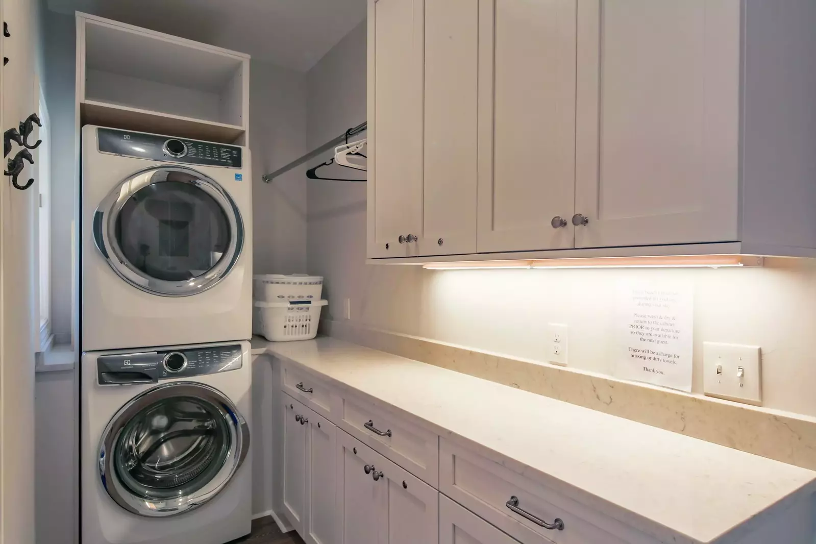 There is a stacked washing machine & dryer in the home.