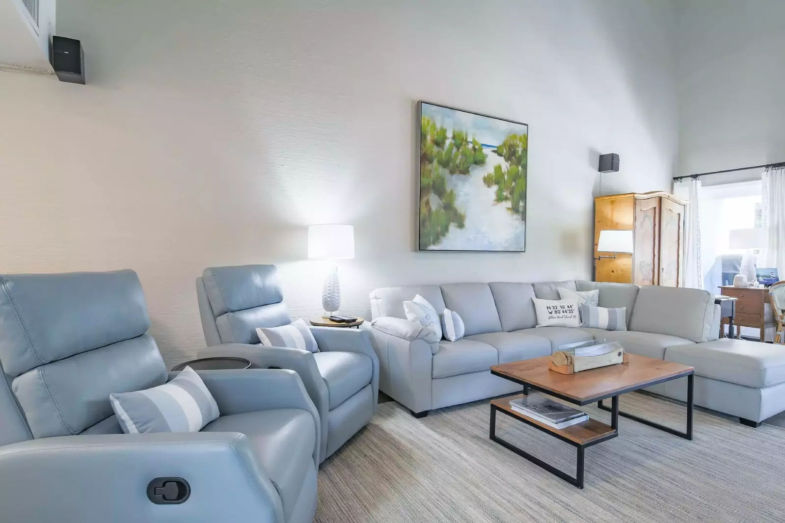 The living room features a spacious sectional and two arm chairs.