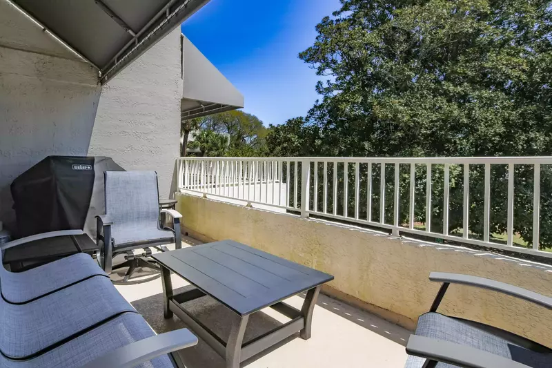 There's a seating area, grill and dining table on the partially-covered balcony.