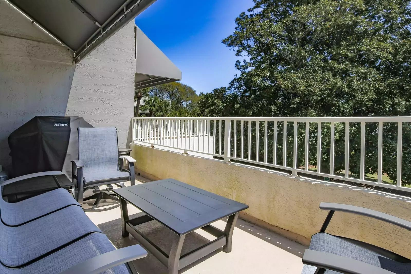 There's a seating area, grill and dining table on the partially-covered balcony.