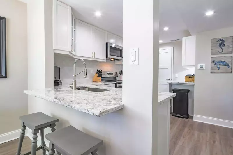 The kitchen features granite counters, white cabinets and stainless steel appliances.