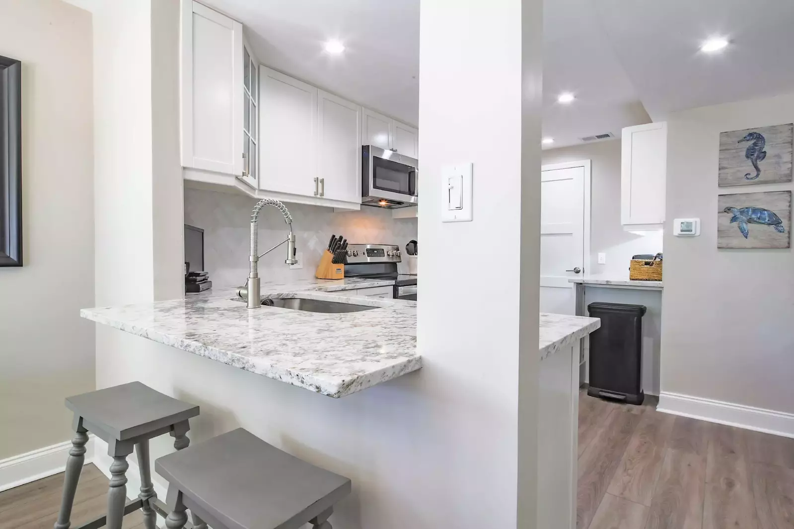 The kitchen features granite counters, white cabinets and stainless steel appliances.
