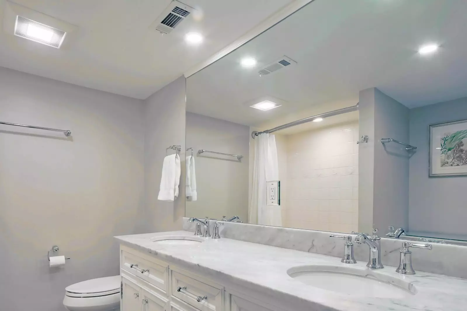This en suite bathroom features a dual-sink vanity and walk-in shower.