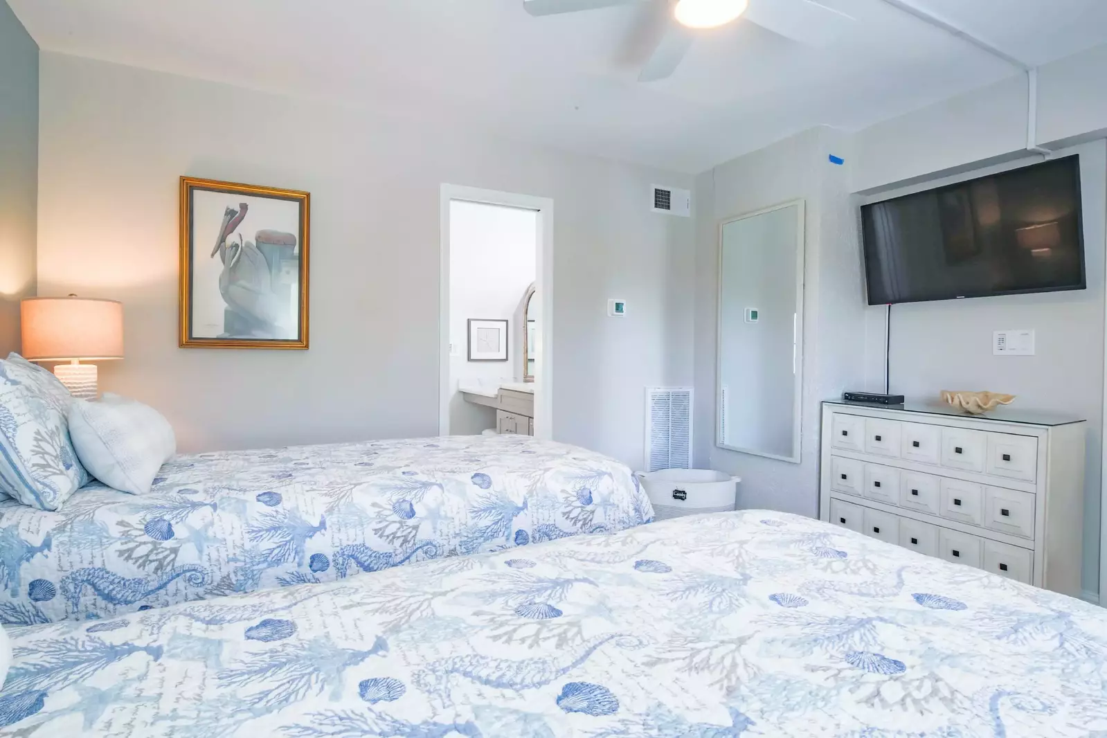 This bedroom also has a dresser, wall-mounted TV and renovated en suite bathroom.