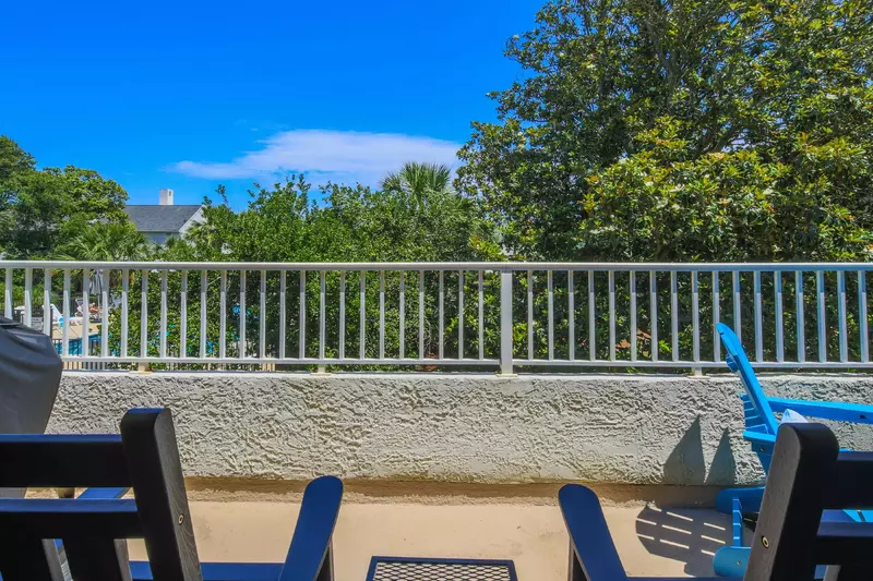 The partially-covered balcony looks out to the community pool area behind the villa.