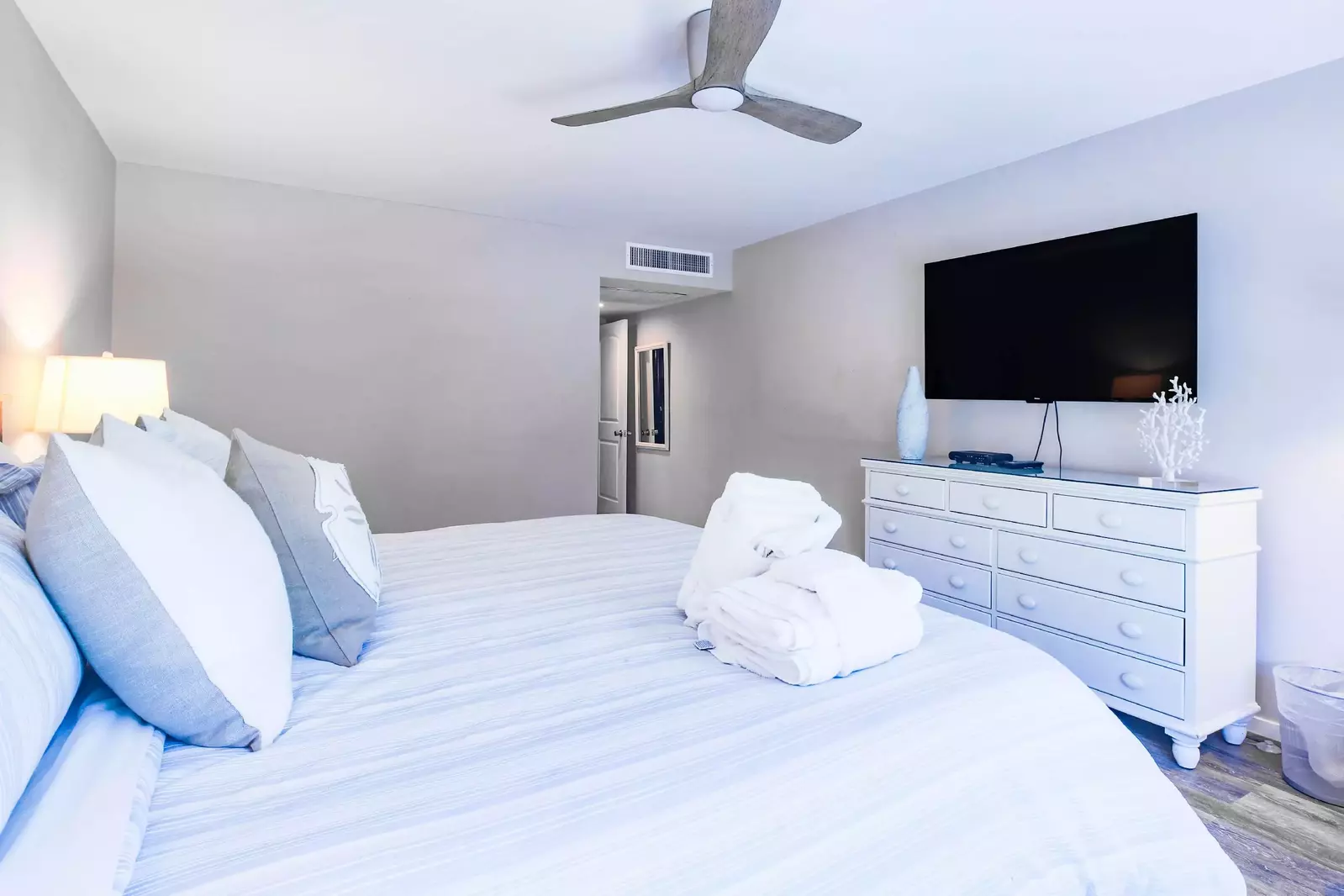 The master suite also has a ceiling fan, dresser and wall-mounted smart TV.