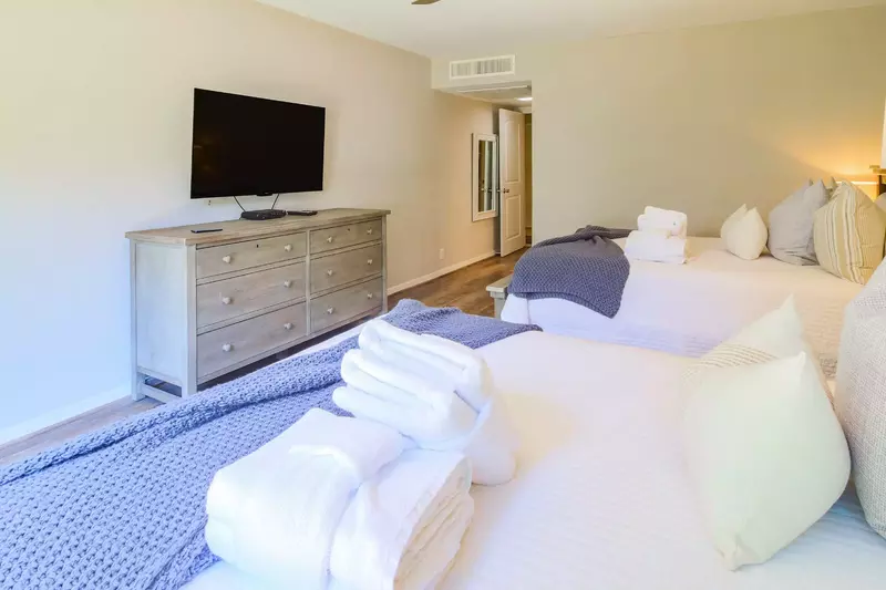 There is a dresser and wall-mounted TV in the guest suite.