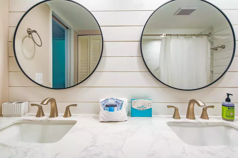 There are his and hers mirrors mounted above the dual-sink vanity.
