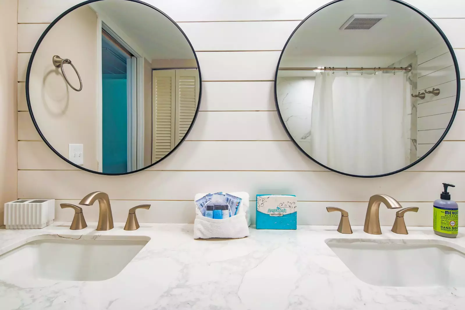 There are his and hers mirrors mounted above the dual-sink vanity.