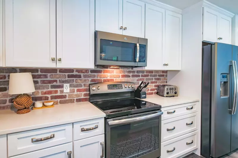 The kitchen features an electric range, microwave and toaster.
