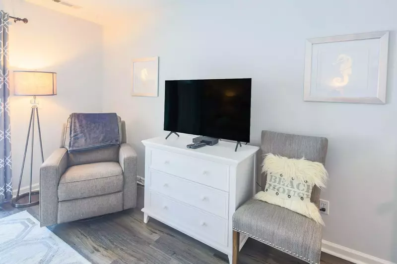 The master suite has two chairs and a floor lamp.