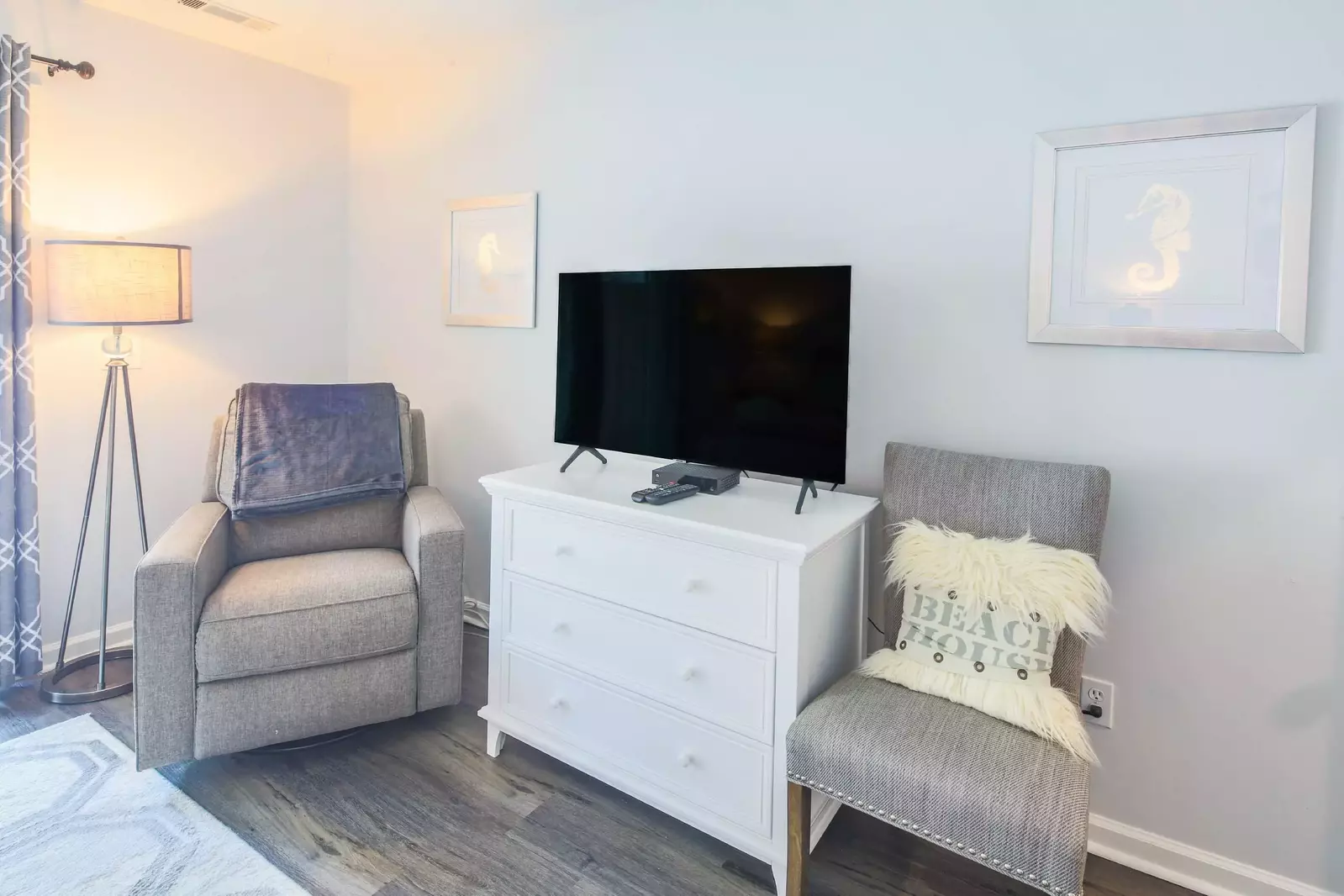 The master suite has two chairs and a floor lamp.