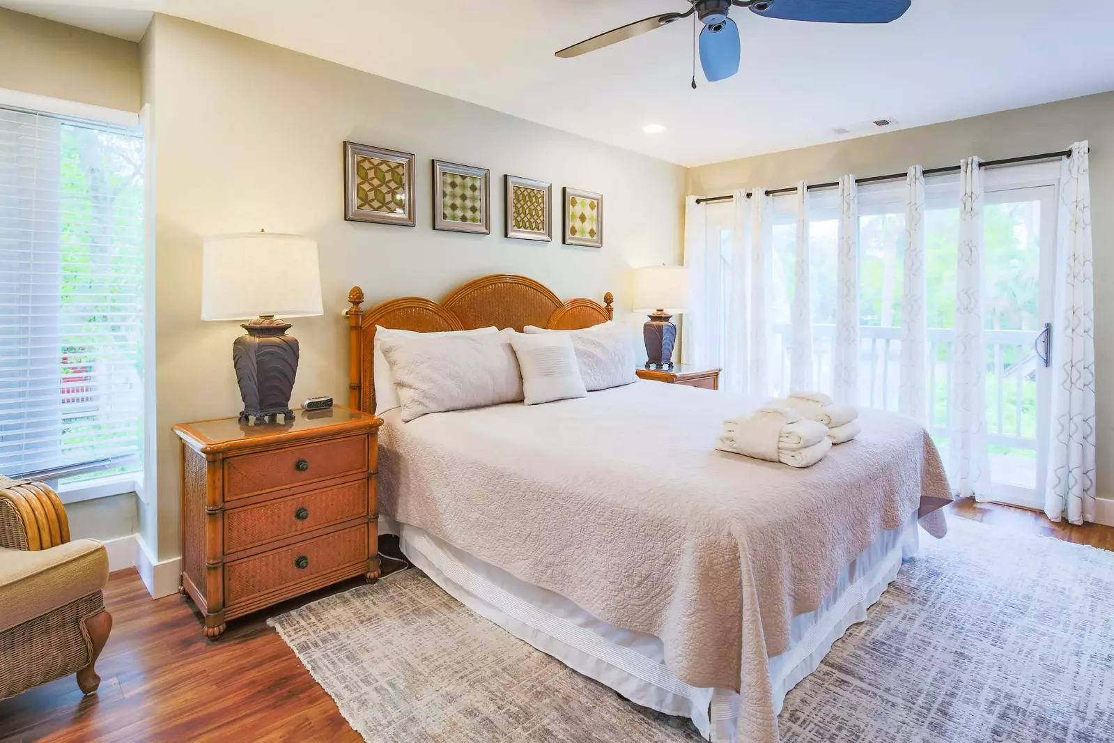 The master suite features a king bed, night stands with reading lamps and sliding door access to the exterior balcony.