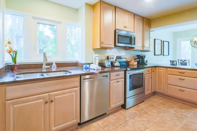The kitchen features granite countertops, stainless steel appliances and tiled floors.
