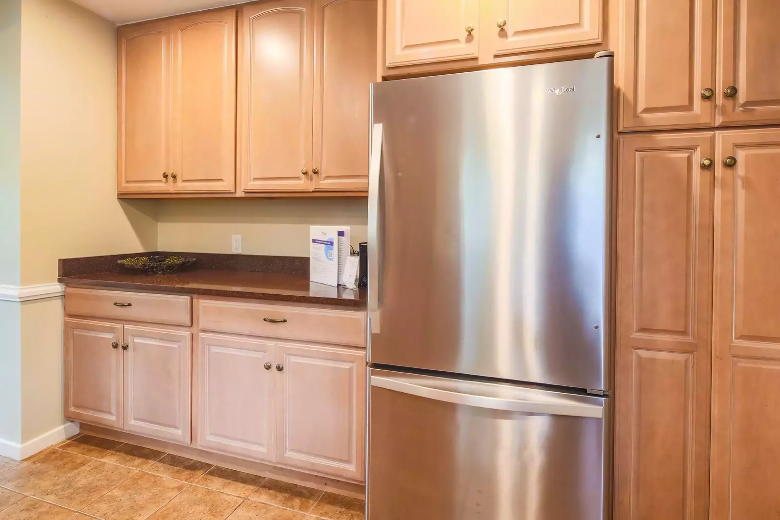 There is a stainless steel refrigerator and additional storage space.