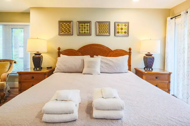 The master suite features a king bed, night stands with reading lamps and an arm chair.