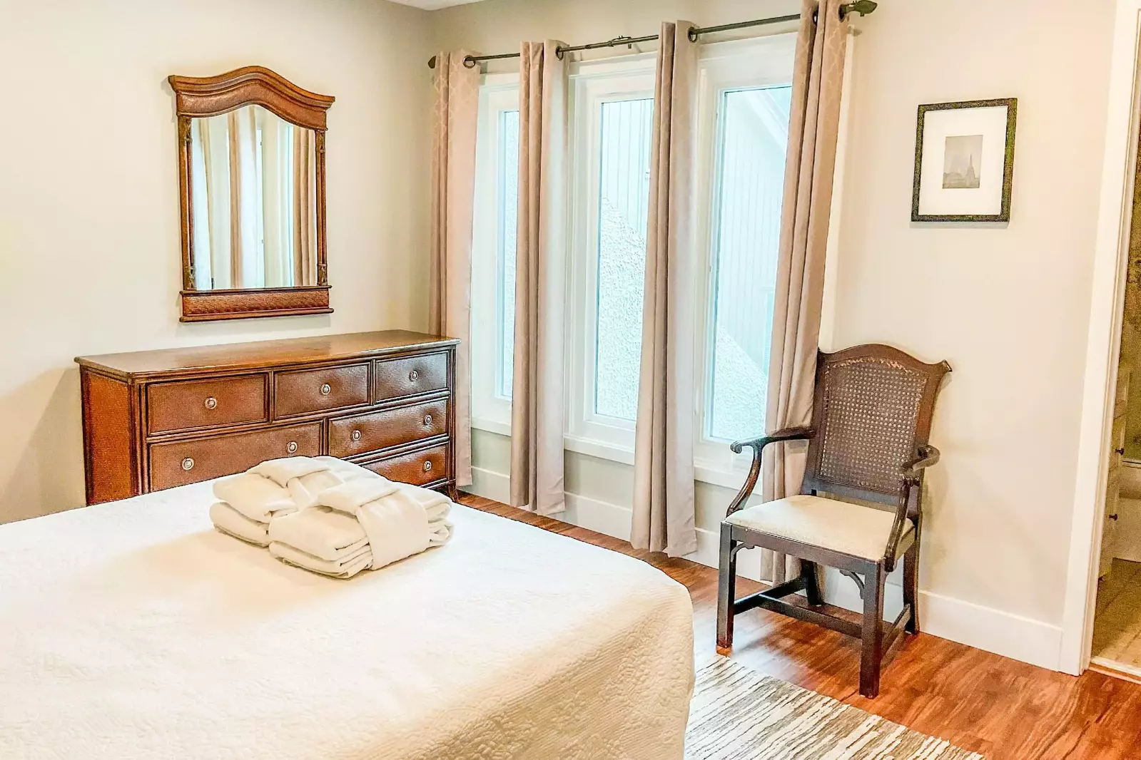 The queen suite also features a dresser, ceiling fan and arm chair.