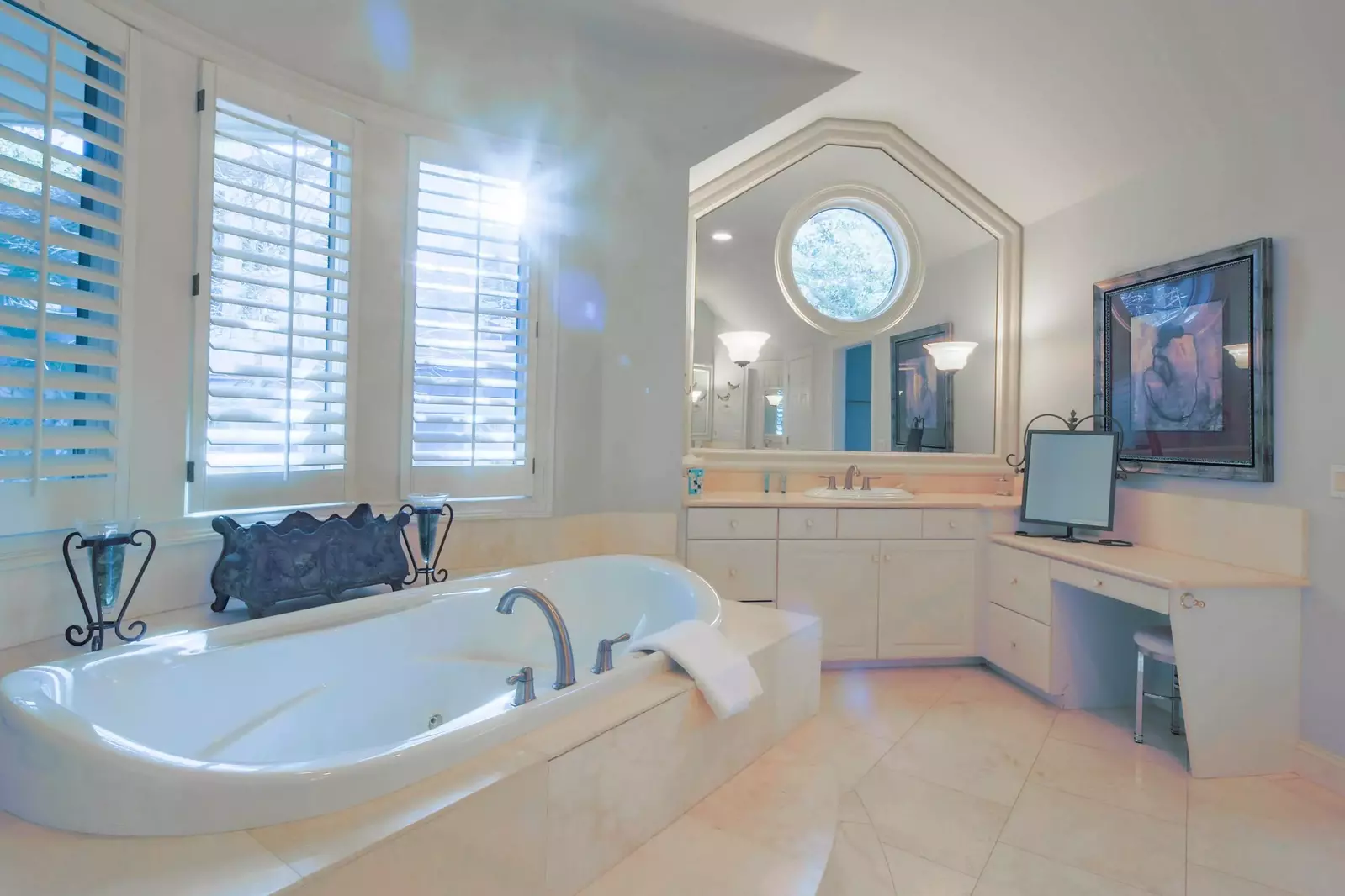 The en suite bathroom features a soaking tub, spacious vanities and makeup table.