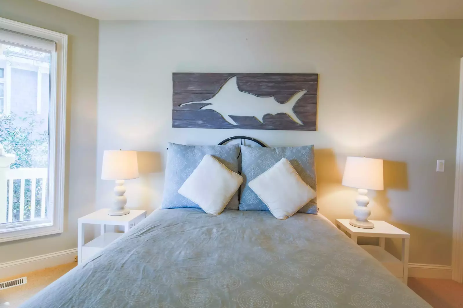 This lower level guest suite features a queen bed and night stands with reading lamps.