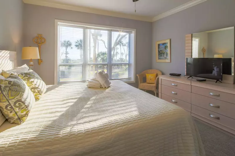 The master suite also has a dresser, chair and flat screen TV.
