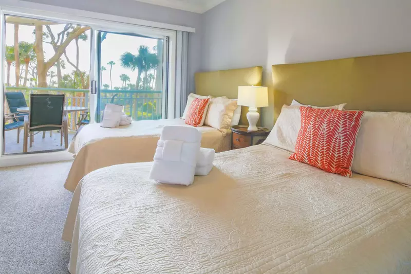 The guest suite features ocean views, two full beds and a night stand with a reading lamp.