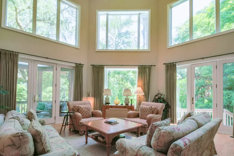 The living room features vaulted ceilings, walls of windows and access to the back deck and screened porch.