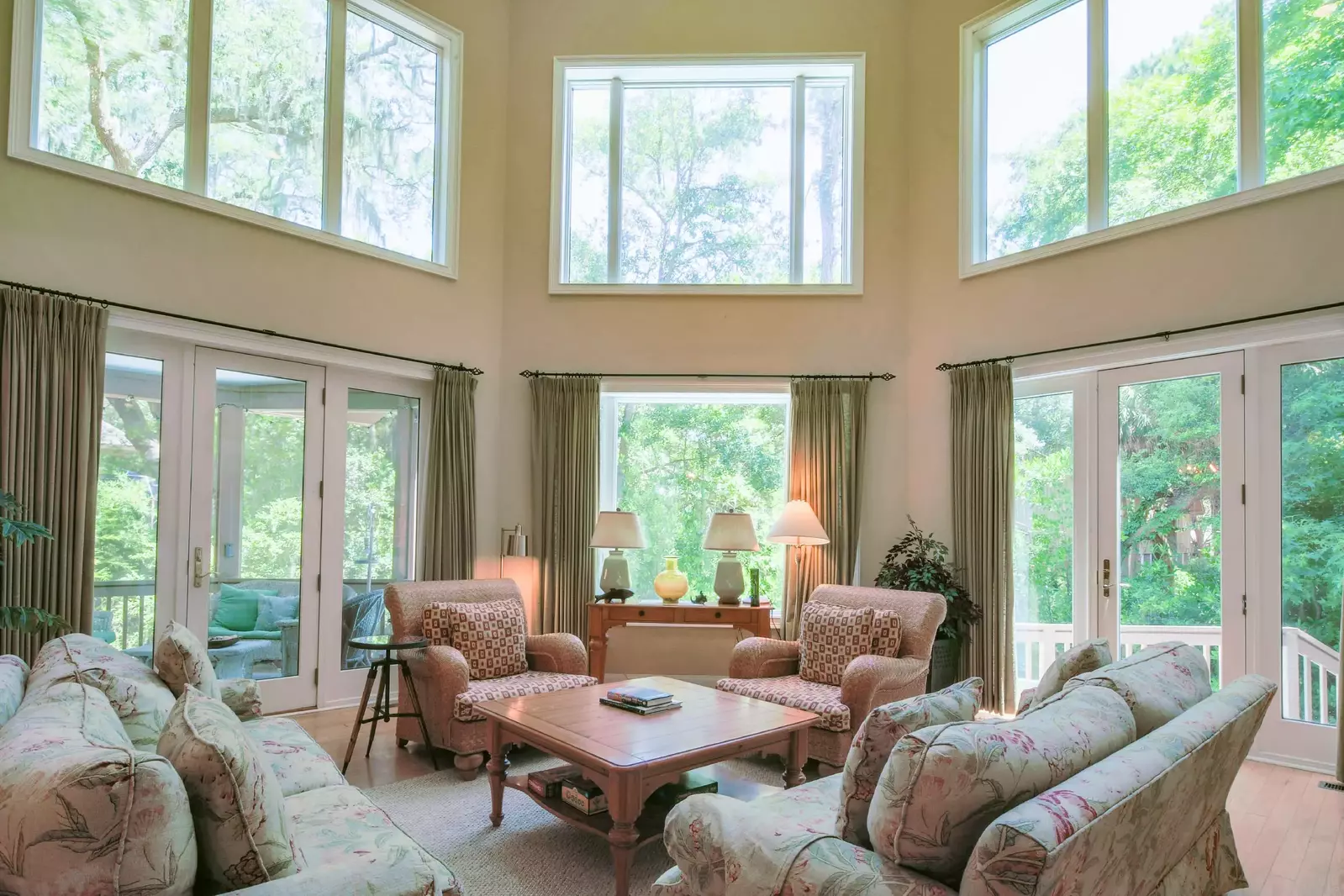 The living room features vaulted ceilings, walls of windows and access to the back deck and screened porch.
