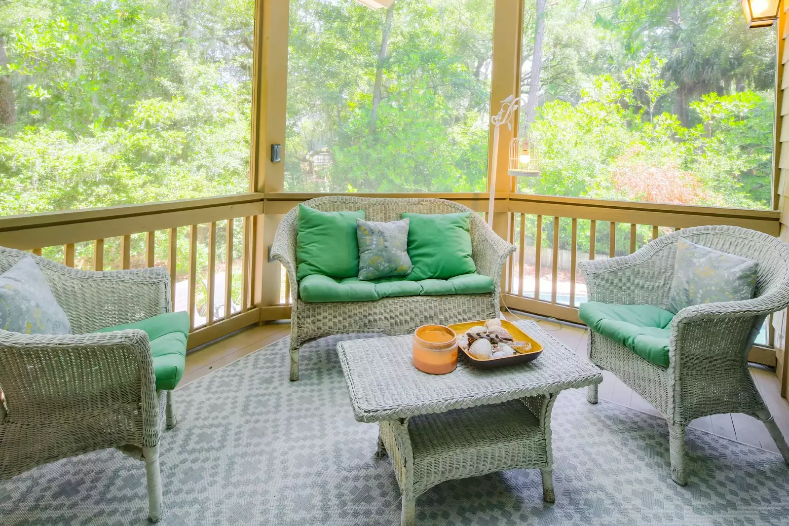 This comfortable seating area on the screened porch overlooks the pool area below.