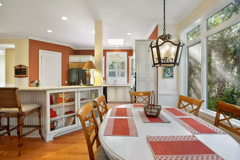 The kitchen table is situated between the den and the kitchen.
