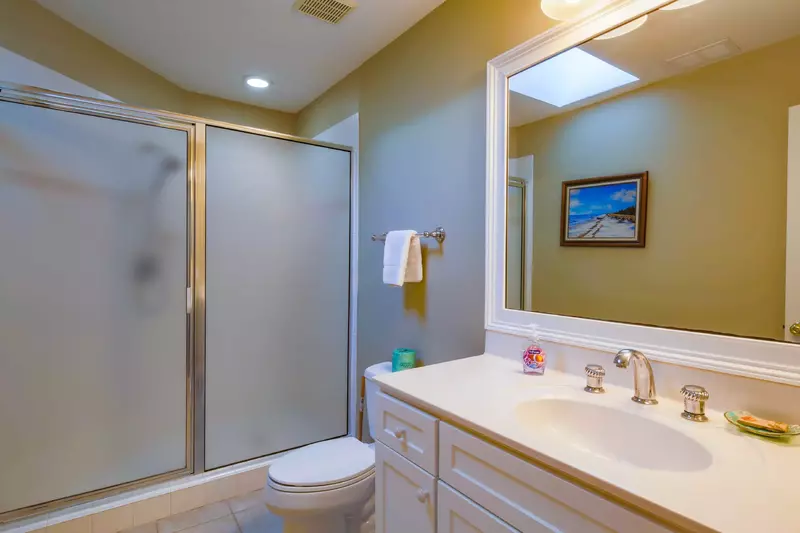 This en suite bathroom features a spacious vanity and a walk-in shower.